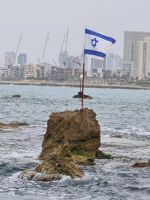 Andromeda's Rock in front of the skyline of modern Tel Aviv.