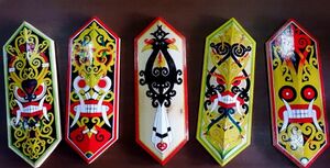 photograph of five shields, the middle one displaying a hornbill